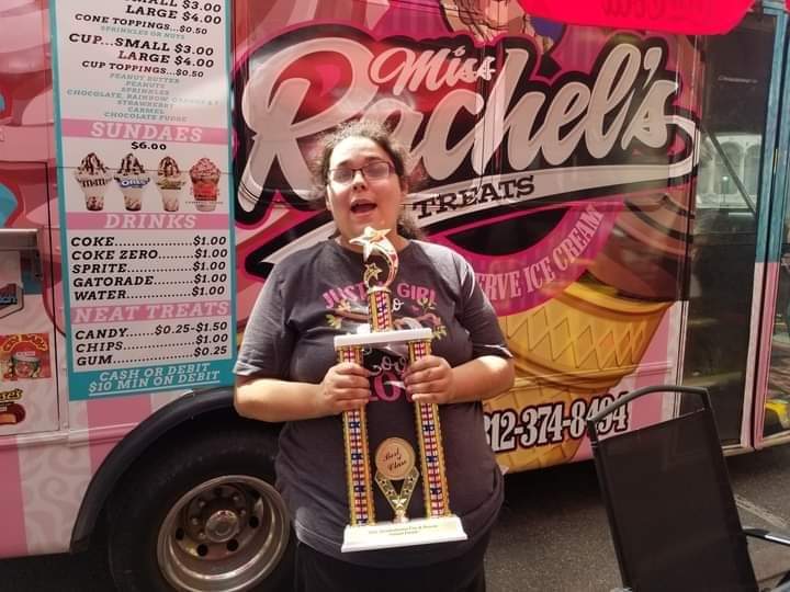 Miss Rachel holding a trophy.